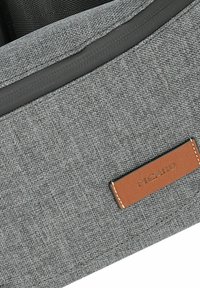 Bolso de tela gris con una superficie texturizada, con ribete oscuro y una etiqueta de cuero marrón grabada con "PICARD". Diseño elegante y detalles mínimos.