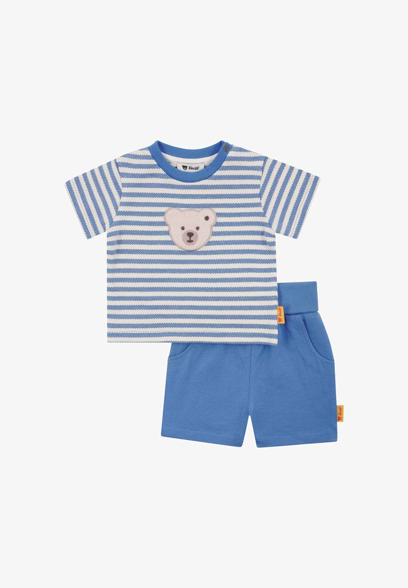 Ubranko dla niemowlaka z niebiesko-białą koszulką w paski z krótkim rękawem i naszywką z misiem, w komplecie z jednolitymi niebieskimi szortami z kieszeniami.