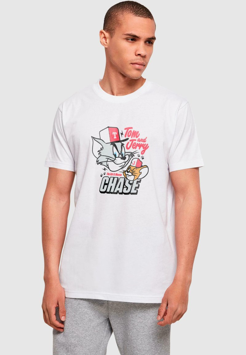 Hvit bomulls T-skjorte med grafikk av Tom og Jerry. Designet inkluderer fargerike illustrasjoner og fet tekst i svart og rødt.