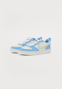 Baskets Nike bleues et blanches avec une combinaison de cuir et de maille, forme arrondie, lacets blancs et un accent de logo subtil.