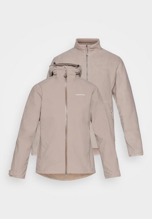 Beige wasserdichte Jacke mit abnehmbarem Kapuzenhut, Frontreißverschluss und zwei seitlichen Taschen. Weiche Innenauskleidung und eine zweite Fleece-Schicht.