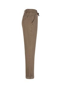 Brune tapered bukser med elastisk talje, sidelommer, baglomme og manchetter ved anklerne vist fra siden på hvid baggrund.