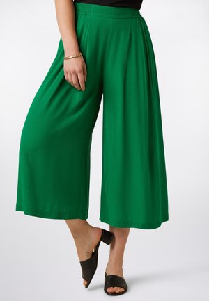 Grüne Hosen mit weitem Bein aus weichem Stoff und elastischem Bund. Sie zeichnen sich durch eine glatte Textur und ein lockeres, fließendes Design aus.