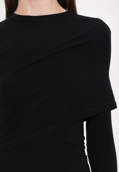 Schwarzes Langarmoberteil aus glattem Stoff, mit einem asymmetrischen Schichtdesign, geschwungenen Nähten und einem runden Halsausschnitt.