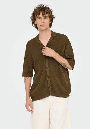 Olive green short-sleeve button-up shirt with a textured pattern and open collar, featuring brown buttons and relaxed fit.