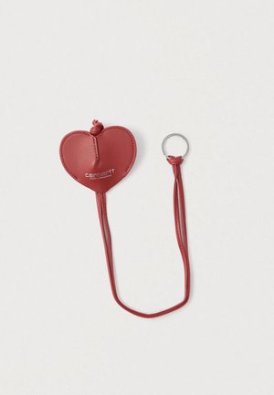 Červená kožená kľúčenka v tvare srdca s hladkým povrchom, obsahujúca očko na pripevnenie a na prednej strane vyrazené logo "Carhartt".