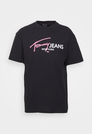 T-shirt en coton noir avec col rond et manches courtes. Présente un logo texte "Tommy JEANS NEW YORK" en blanc et rose dans un design audacieux.