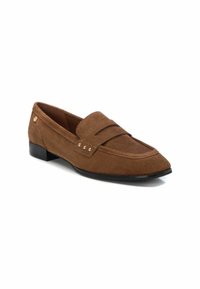 Mocasín de ante marrón con puntera afilada, que presenta una correa en la parte superior y sutiles acentos dorados. Tacón plano negro. Textura suave.