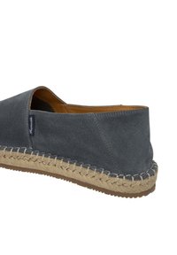Scarpa slip-on in suede grigio con suola in corda di juta, caratterizzata da un tallone arrotondato e dettagli cuciti lungo il bordo.