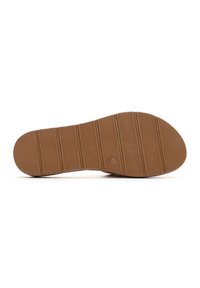 Suela de zapato de goma marrón con textura estriada y líneas horizontales, con un logo circular estampado cerca de la zona del talón.