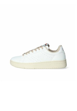 Sneaker in pelle bianca con lacci e rivestimento beige, caratterizzata da dettagli perforati sui lati e una suola in gomma di colore chiaro e texture.