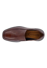 Zapato marrón de cuero sin cordones con punta cuadrada, acabado suave, costuras en contraste y suela de goma flexible. El interior cuenta con una plantilla acolchada.