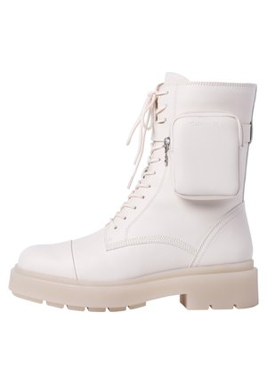 Bota de combate blanca con cordones, suela gruesa y pequeña bolsa con cremallera adjunta en el lateral.