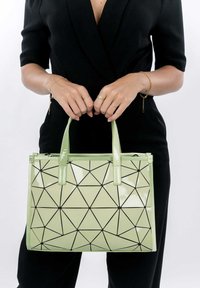 Borsa a tracolla in pelle verniciata verde con motivo geometrico nero, doppi manici, chiusura con zip e forma rettangolare strutturata.