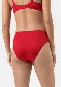 Rode naadloze onderbroek met een hoge taille, gladde textuur en elastische tailleband. Heeft een minimalistische achterkant zonder zichtbare naden.