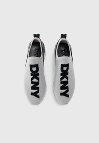 Szare buty sportowe typu slip-on z czarnym logo "DKNY". Dzianinowa cholewka, teksturowane wykończenie, elastyczna konstrukcja oraz gumowa podeszwa z wspierającym obcasem.