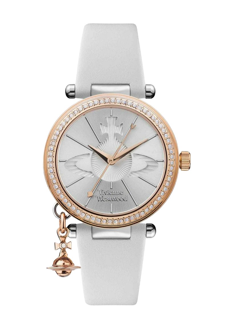 Montre argentée avec un cadran rond, des accents en or rose, un bracelet en silicone blanc et des embellissements en cristal. Elle comprend un charme avec une petite cloche.