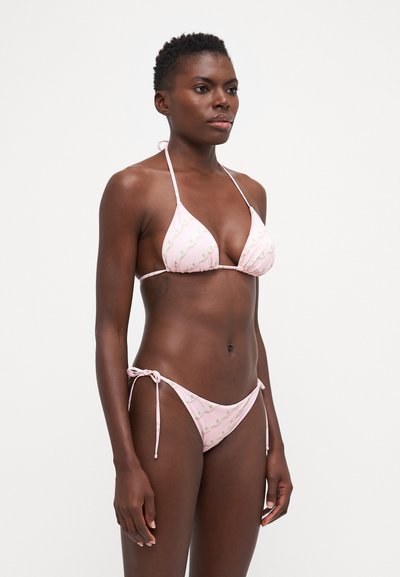 Σετ μπικίνι τριγώνου σε παστέλ ροζ χρώμα, με κυματιστό σχέδιο. Ρυθμιζόμενα κορδόνια στο τοπ και στα σλιπ, κατασκευασμένο από απαλό και ελαφρύ ύφασμα.