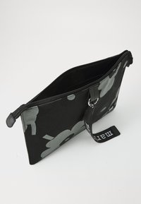 Black fabric clutch bag with gray floral pattern, zip closure, and a side handle. Interior is plain black. Simple, rectangular design.