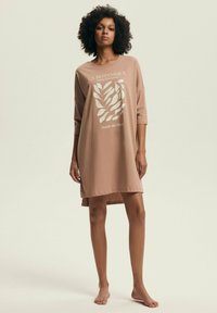 Różowa, oversize sukienka z miękkiego materiału, z graficznym wzorem liści i rękawami 3/4, o asymetrycznym dołku.