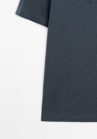 Mørkeblå t-shirt med korte ærmer, lavet af tekstureret stof og rund halsudskæring. Har en ren kant og minimalt syningsdetaljer.