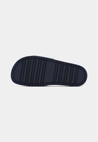 Dark blue rubber shoe sole with horizontal grooves and subtle "BOSS" branding in the center on a white background.