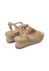 Sandalias de cuña de ante beige con múltiples correas y hebilla en el tobillo. Borde de plataforma tejido texturizado decorado con acentos metálicos.