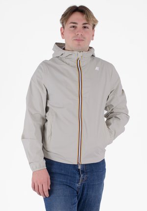 Giacca a vento beige chiaro con cappuccio, dotata di una zip frontale con una striscia multicolore e polsini elasticizzati. Vestibilità casual con tasche laterali.