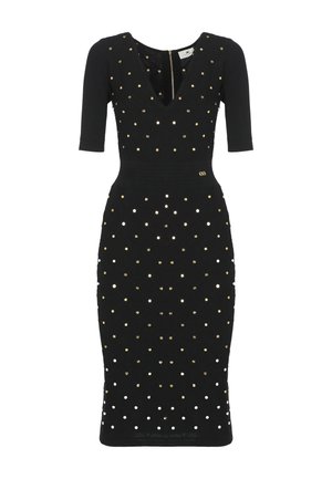 Abito nero aderente al ginocchio con maniche a tre quarti, scollo a V e decorazioni con borchie circolari oro e argento.