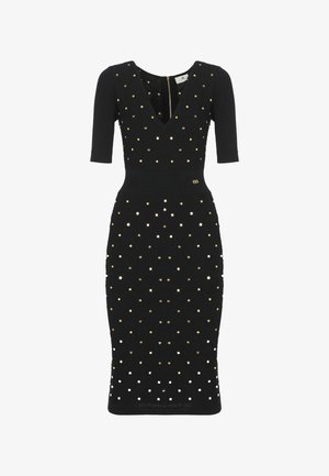 Abito nero aderente al ginocchio con maniche a tre quarti, scollo a V e decorazioni con borchie circolari oro e argento.