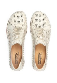 Zapatos de cuero perforado color crema con puntera redonda, diseño de cordones y suela plana marrón. Presentan una textura suave y recortes decorativos.