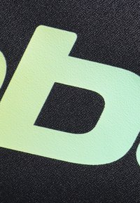 Struktureret sort baggrund med et stort, glat, mintgrønt bogstav "d" delvist synligt, der viser en mat finish.