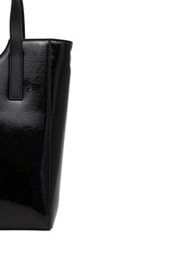 Sac cabas en cuir verni noir avec une finition lisse et brillante et une anse renforcée cousue sur un fond blanc.