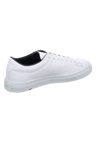 Sneaker blanc avec un extérieur en cuir lisse, bout rond, semelle en caoutchouc épaisse et design minimaliste. Doublure intérieure et lacets noirs.
