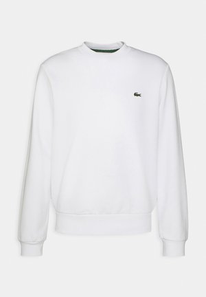 Sweat-shirt blanc à manches longues avec col rond, poignets et ourlet côtelés, arborant un petit logo crocodile vert sur la poitrine gauche.