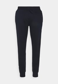 Svarta tapered sweatpants med elastiskt midjeband och uppvikta anklar, med en liten bakficka på högra sidan.