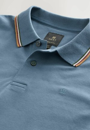 Polo shirt blu in tessuto strutturato con colletto decorato da strisce verdi, rosse e gialle, e un piccolo logo ricamato sul petto.