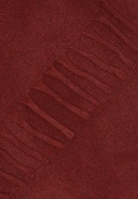 Écharpe bordeaux avec une texture douce, présentant des bords frangés et une surface lisse, idéale pour la chaleur et le confort.
