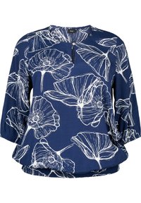 Blouse bleu marine en tissu doux avec un imprimé floral blanc. Elle présente un col rond et des manches trois quarts avec des poignets froncés.