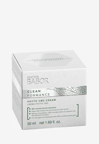 Caja cuadrada blanca con acentos plateados. Presenta el texto "DOCTOR BABOR CLEAN FORMANCE PHYTO CBD CREAM." Gráficos hexagonales en los lados. 50 ml.
