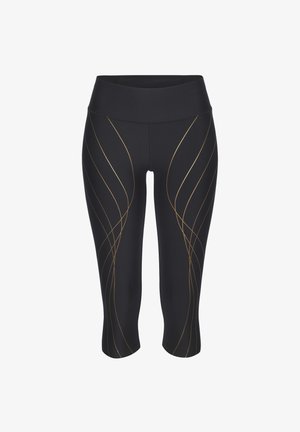 Black capri leggings with a high waistband, featuring gold wavy lines as a pattern. Made of stretchable fabric for comfort and movement.