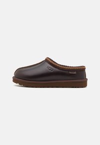 Brown leather slip-on clog with contrasting brown stitching and rubber sole, featuring a branded accent on the side.