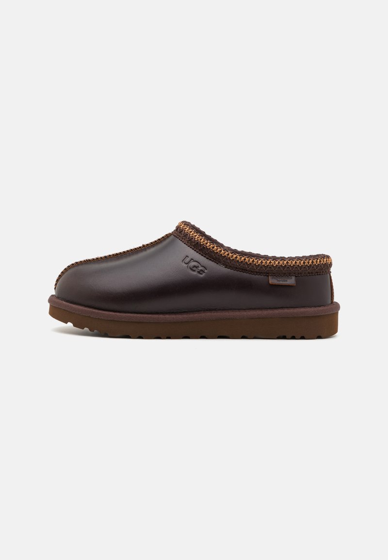 Brown leather slip-on clog with contrasting brown stitching and rubber sole, featuring a branded accent on the side.