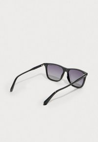 Μαύρα γυαλιά ηλίου με γυαλιστερό σκελετό, τετράγωνα φακοί που ξεθωριάζουν από σκούρο σε ανοιχτό γκρι, με λεπτά μαύρα βραχίονες.