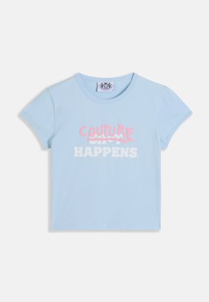 Šviesiai mėlynas trumpomis rankovėmis crop top'as su „COUTURE“ rožinėmis grafiti stiliaus raidėmis virš baltos „SHIT HAPPENS“ slogano.