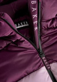 Fialová nafukovacia bunda s čiernym zipsom a brandingom "BAKER". Saténová textúra s kontrastnou svetloružovou časťou.