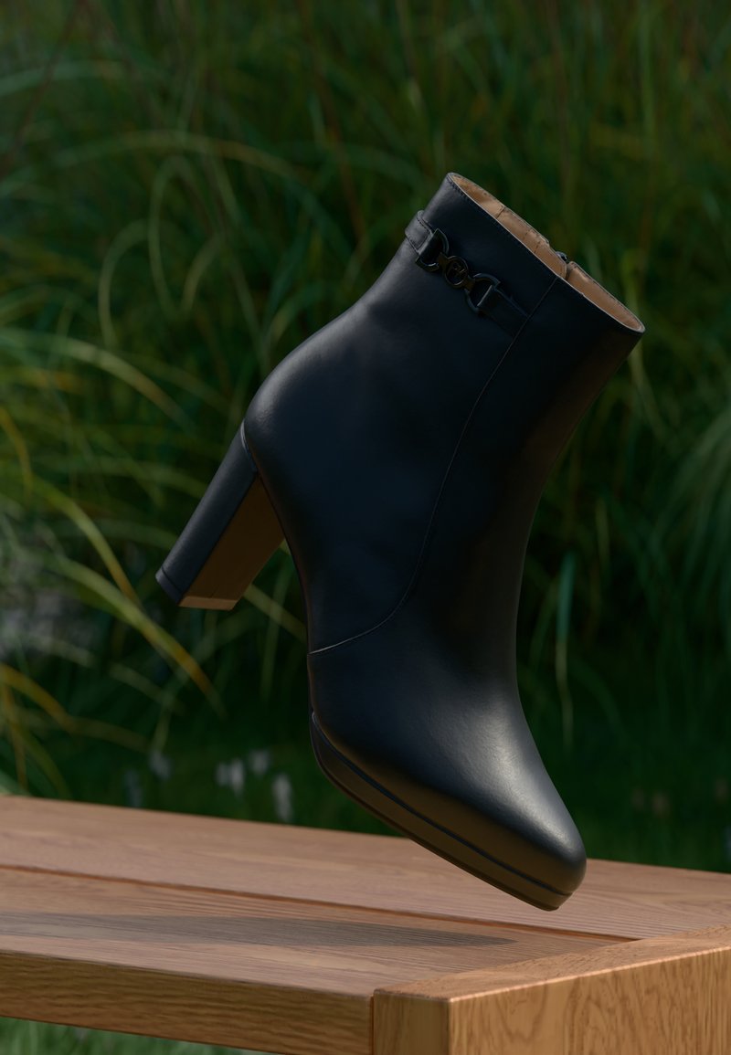 Bota de tornozelo em couro preto com bico alongado e salto bloco médio. Apresenta um detalhe decorativo em corrente e textura suave.