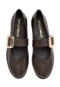 Un par de zapatos Mary Jane de color marrón oscuro con hebillas doradas y plantillas negras texturizadas, etiquetados como "RYEKO RELAX" en el interior.