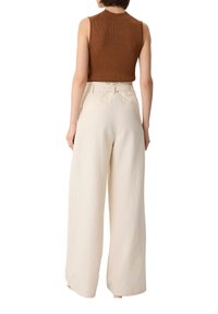 Bruine mouwloze ribben top gecombineerd met hoogwaardig beige wijde broek, met een gladde textuur en minimalistisch ontwerp.
