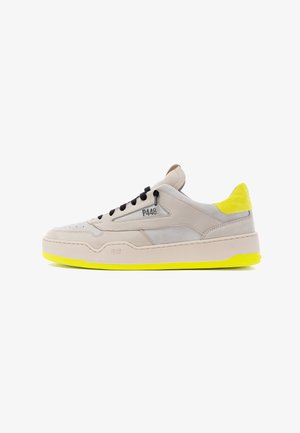 Sneakers en suédine beige et cuir avec lacets noirs, accents jaunes au niveau du talon et de la semelle, et logo P448 sur le côté. Design à bout rond.